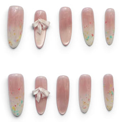 Press-on Nail |Fairycore Style |3D Ribbon Bows |Medium Almond Shap -Ten false press-on nails arranged in two rows on a white background. The nails are almond-shaped with a soft pink-to-white ombre gradient and multicolor confetti speckles, with one nail in each row featuring a small white fabric bow detail.