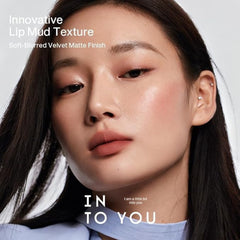 Close-up beauty advertisement showing a woman with matte lip color and soft blush, with text reading 'Innovative Lip Mud Texture' and 'IN TO YOU'.- INTO YOU SHERO SUPER MATTE LIP&CHEEK MUD 2G-EM08 BROWN-TAUPE/ BRICK RED NUDE-The Cosmetic Store