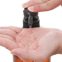 Hand holding a black spray bottle with clear liquid being dispensed onto another hand -KUMANO YUSHI Horse Oil Rinse-in Shampoo 600ml 2 IN 1 Hair Shampoo & Conditioner - THE COSMETIC STORE NZ