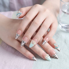 Press-on Nail | Y2K Zebra Stripe French Tips Style | Almond Shap
-A close-up of hands showcasing a manicure with long, almond-shaped nails decorated with black and white zebra stripes, light blue pastel tips, and delicate white floral embellishments.