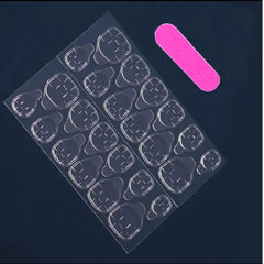 A sheet of clear plastic nail art stickers with multiple teardrop-shaped cutouts, shown on a dark navy background next to a pink nail file.