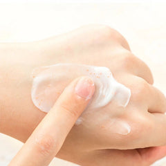 Hand applying a skincare product with a focus on texture and application- Shiseido hand cream deep repair moisturising treatment NZ
