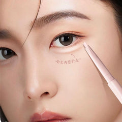 Close-up of a person applying makeup with a brush near their eye.-Under eye brightening and contour pen close up