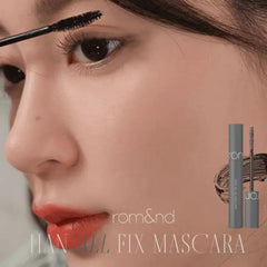 Close-up of a woman applying mascara with a brush, featuring rom&nd mascara packaging.