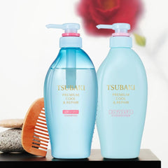 Two bottles of Tsubaki shampoo and conditioner with a comb and floral camellia