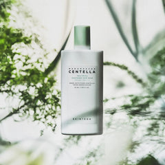 Skincare bottle with green cap and white label against a blurred natural background