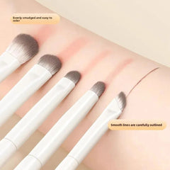 Set of makeup brushes with white handles and brown bristles 