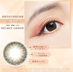 Eye with brown contact lenses labeled 'Secret Amber' on a beige background