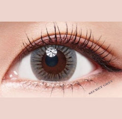 Close-up of an eye wearing a gray contact lens with 'Secret Grey' text.