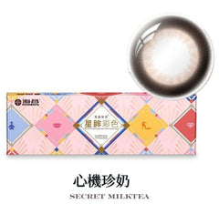 Color-changing contact lens with packaging labeled 'Secret Milk Tea' on a white background