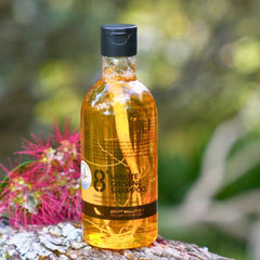 Bottle of 8 Minute Ginseng Shampoo on a natural background with flowers and greenery.
