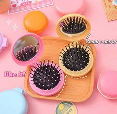 Set of hairbrushes with mirrors on a pink background