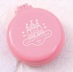 Pink compact mirror with castle design and 'Cosmetic Store' text on a light pink background