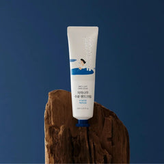Hand cream tube on a wooden block with a blue background
