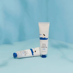 Two tubes of hand cream on a light blue background