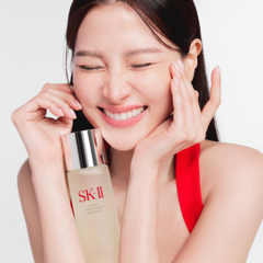 Woman holding an SK-II skincare product with a plain background-SK-II Facial Treatment Essence bottle and red box 160ml [Japan Domestic Versions]-available at The Cosmetic Store NZ