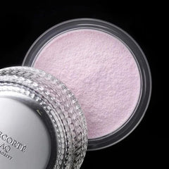 Makeup product with a textured surface and decorative lid on a black background