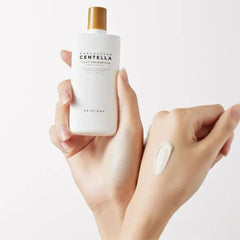 Hand holding a skincare product labeled 'Ceramidin Centella' with a small amount of cream on another hand.