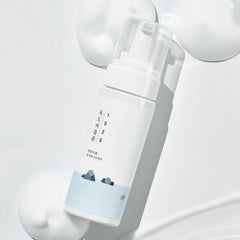 White spray bottle with a blue label on a light gray background