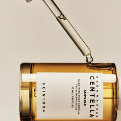 Centella Madagascan skincare ampoule bottle with dropper on a beige background