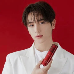 Person holding a red bottle against a red background