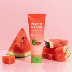 A tube of TONYMOLY Watermelon Soothing Gel Cream stands upright on a pink reflective surface, flanked by fresh watermelon slices and wedges against a soft pink background.- TONYMOLY Watermelon Soothing Gel Cream 120ml | Oily & Sensitive Skin-THE COSMETIC STORE NZ