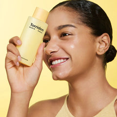 Woman holding a bottle of Torriden product -Torriden SOLID IN All Day Essence 100ml 