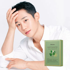 Person wearing a white shirt with a green skincare product box on a white background