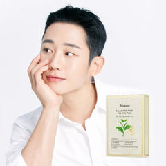 Man touching his face with a JMsolution tea tree mask box on a white background