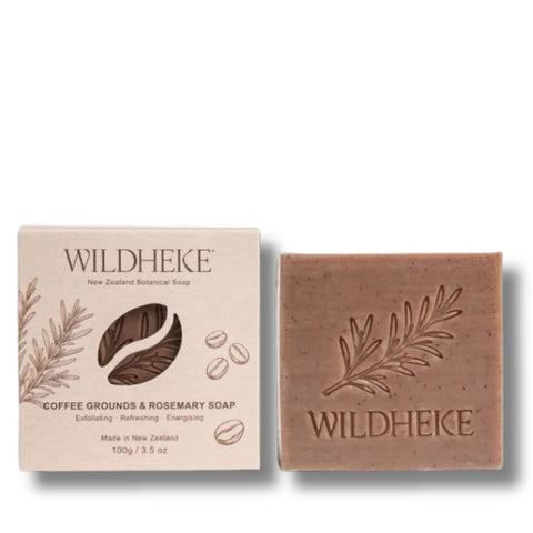 • Wildheke Coffee Grounds and Rosemary Exfoliating Soap 100g bar in plastic free packaging at The Cosmetic Store- Wildheke Coffee Grounds and Rosemary soap shown with its beige paper packaging box and the solid brown soap bar beside it on a white background.
