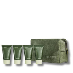 Wildheke Essential Travel Kit 4x25ml mini bottles with pouch at The Cosmetic Store NZ-A Wildheke travel set featuring four dark green toiletry tubes with pale green caps lined up next to a matching dark green zippered pouch on a white background.