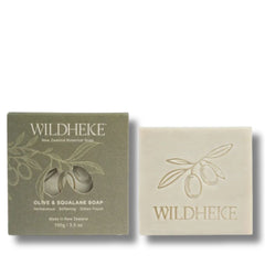 • Wildheke Olive and Squalane Hydrating Soap 100g bar in plastic free box at The Cosmetic Store- Wildheke Olive & Squalane Soap shown with its olive-green box and the cream-colored soap bar beside it on a white background.