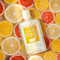 A bottle of Yanagiya Hair Tonic with citrus fruit slices in the background.-Yanagiya Hair Tonic Citrus 240ml- THE COSMETIC STORE NZ