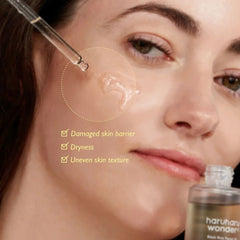 Close-up of a woman's face with text highlighting skin issues and a bottle of skincare product.-Model applying Haruharu Wonder facial oil for a radiant dewy glass skin glow finish