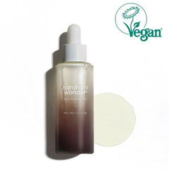 A bottle of Charuharu Wonder Black Rice Facial Oil with a white dropper cap, shown next to a circular swatch of the pale cream-colored oil and a green Vegan logo 