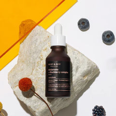 MARY&MAY Idebenone Blackberry Complex Serum (80ml) Seoul Edition- Skincare serum bottle labeled 'Mary & May' on a stone surface with berries around